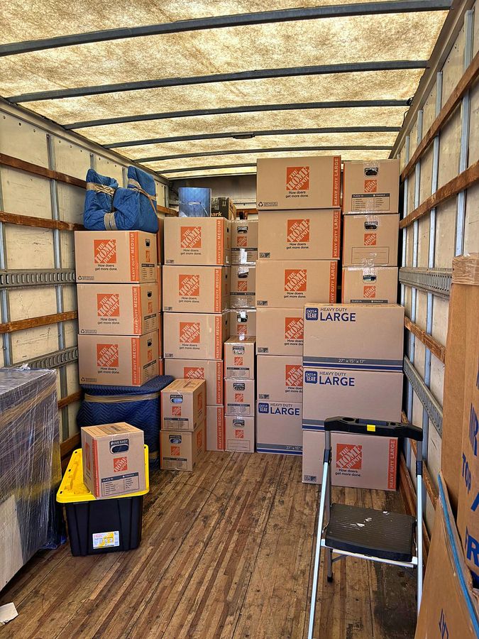 Interior of a Discount Movers truck packed with labeled moving boxes stacked to the ceiling
