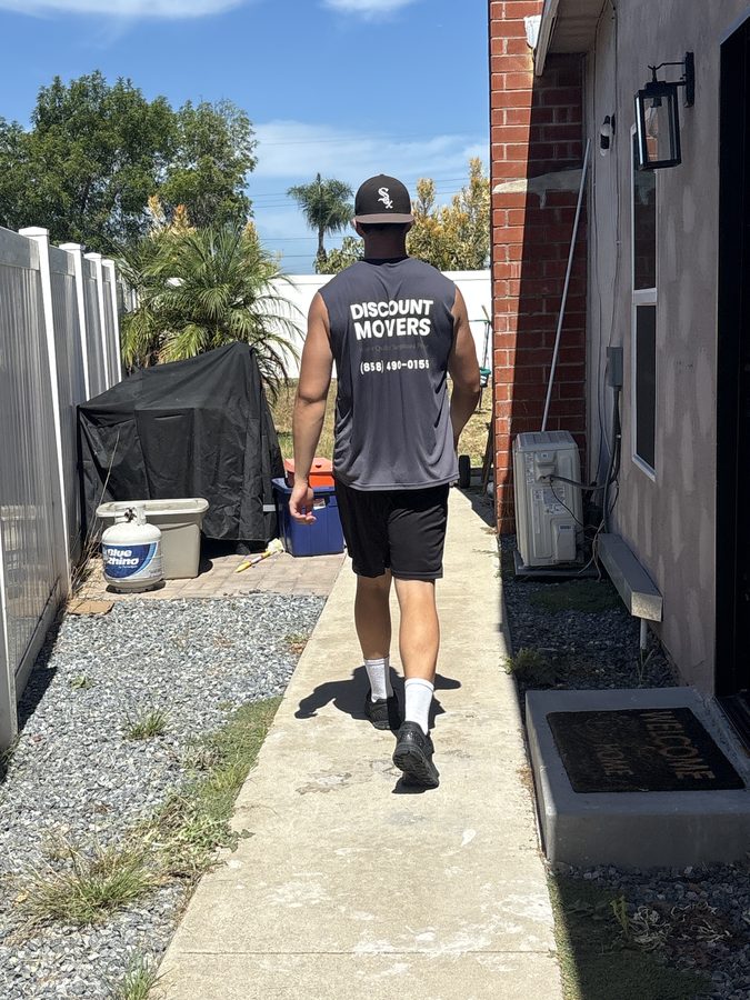 Discount Movers crew member in the company shirt walking up a customer's side path on a move day