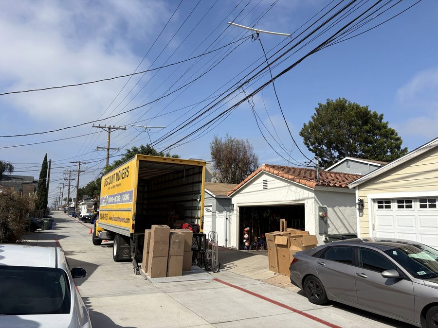 Discount Movers truck backed into a Coronado alley with boxes staged at an open garage